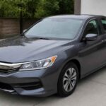 Ciemnoszara Honda Accord zaparkowana na podjeździe przed domem