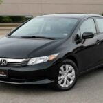Czarna Honda Civic sedan zaparkowana na placu przed budynkiem